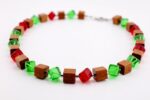 Handgefertigte Würfelkette aus Pau Rosa Holz und Glasperlen in Rot und Grün. Natürliches Edelholz trifft auf farbige Akzente – einzigartiger Schmuck von HotzenArt.