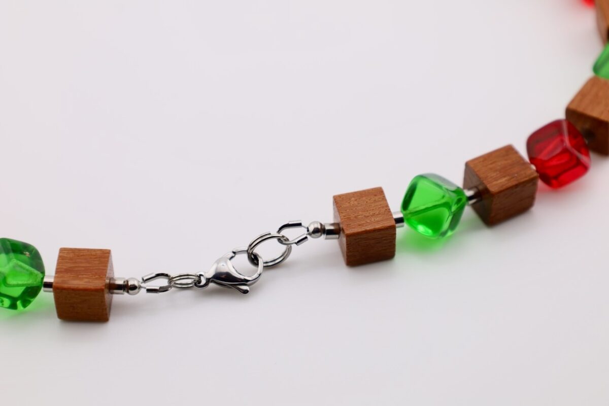 Handgefertigte Würfelkette aus Pau Rosa Holz und Glasperlen in Rot und Grün. Natürliches Edelholz trifft auf farbige Akzente – einzigartiger Schmuck von HotzenArt.